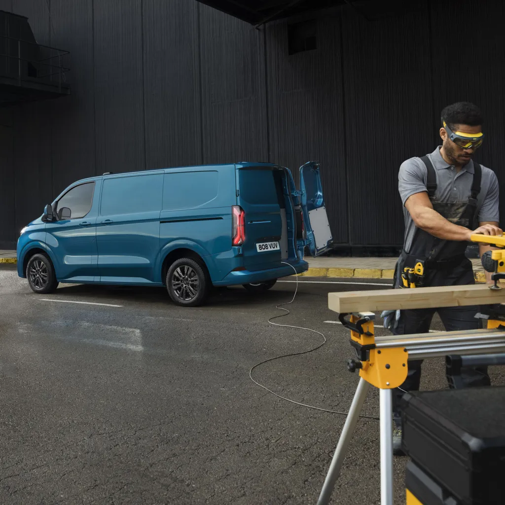 Håndverker får ladning fra elektrisk varebilen Ford E-transit Custom.