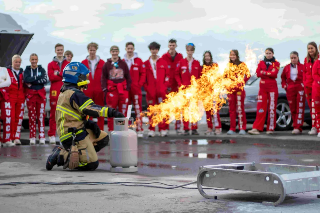 Brannmann demonstrerer slukking for russen hos Sommerseth i Narvik 2023.